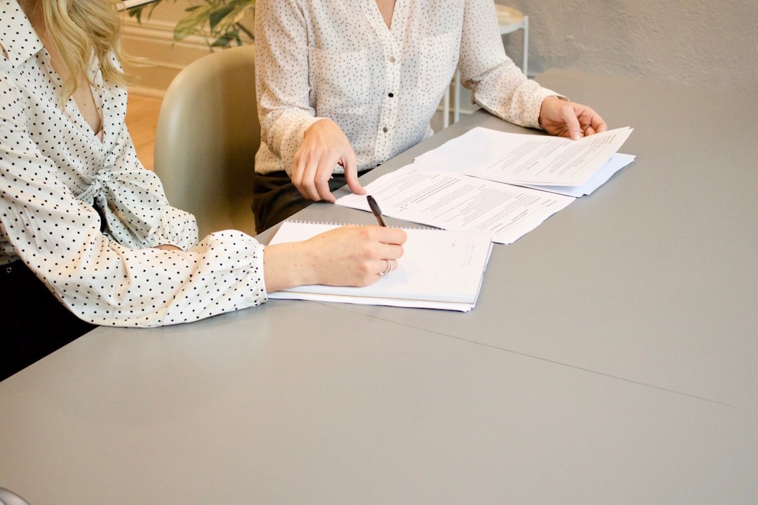A person signing financing paperwork at a dealership - Used cars SLC